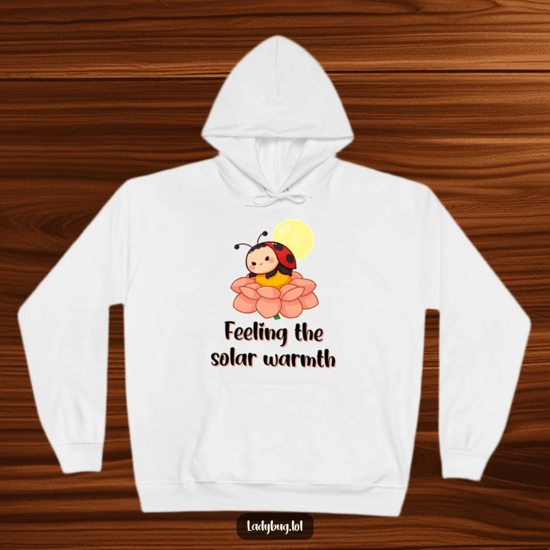 Funny ladybug hoodie featuring a content character sunbathing on a colorful flower petal, offering warmth, comfort, and a dose of humor.