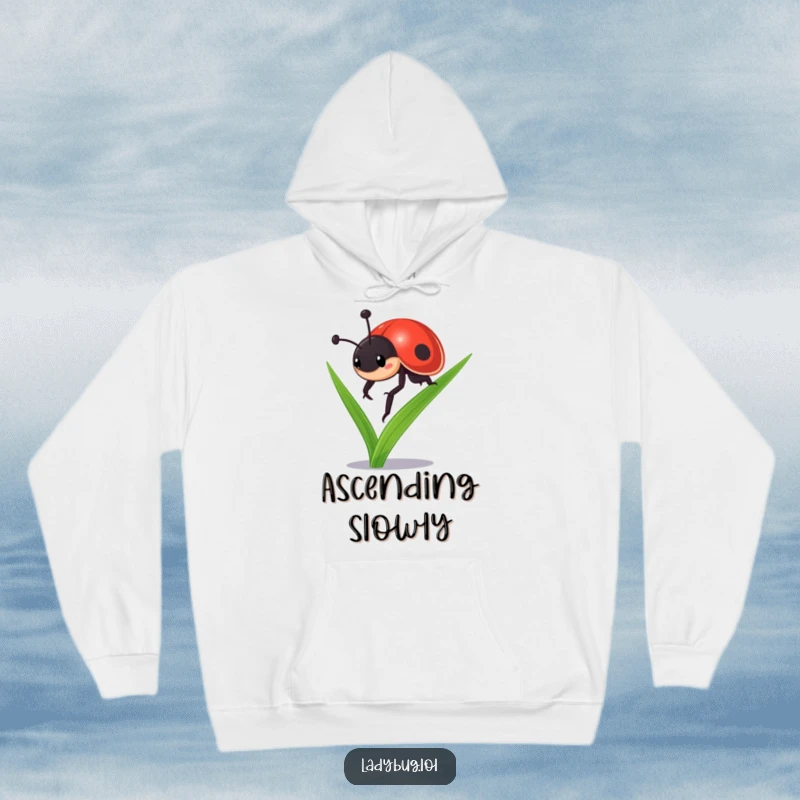 Funny ladybug hoodie: a tenacious ladybug character bravely climbing a blade of grass, expressing resilience and a can-do attitude.