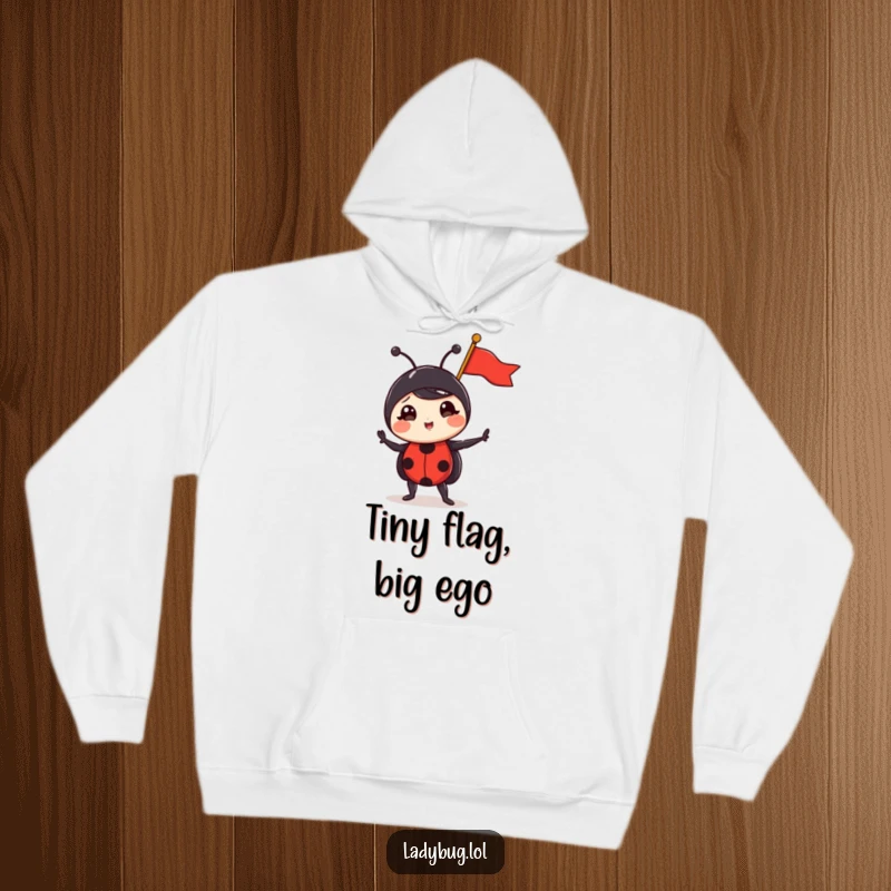 Funny ladybug hoodie with a comically triumphant ladybug holding a tiny flag, radiating an aura of small but mighty victory, ideal for gifting.