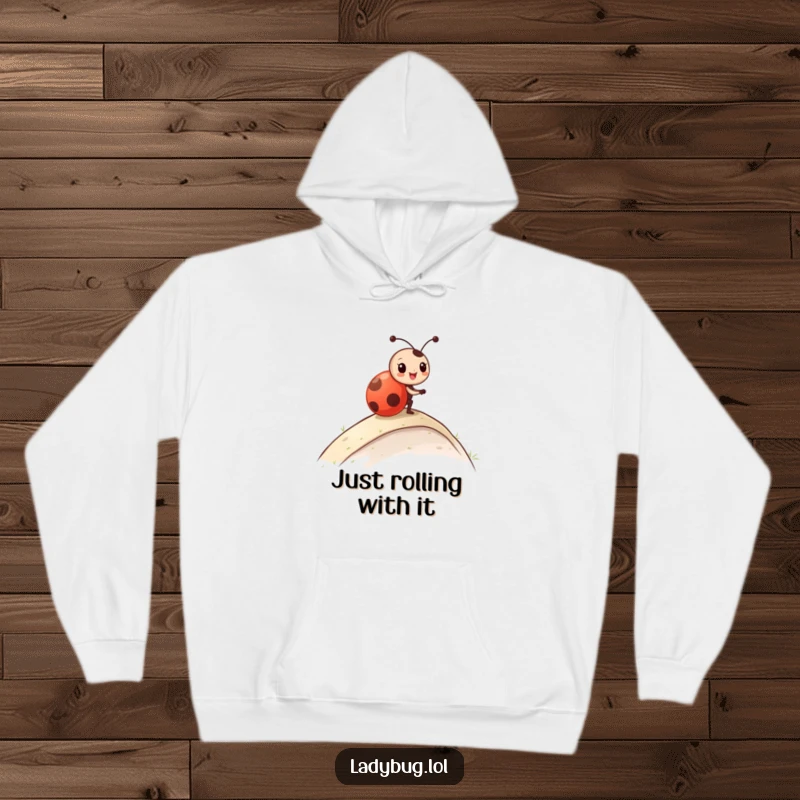 Funny Hoodie with a ladybug character caught in a joyous roll down a gentle incline, radiating fun and excitement.
