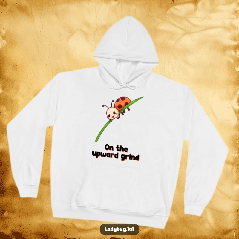 Funny ladybug hoodie featuring an enthusiastic insect character determinedly crawling up a tall blade of grass, feeling motivated.